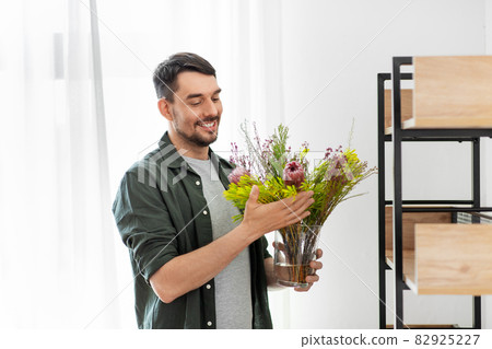man decorating home with flower or houseplant 82925227