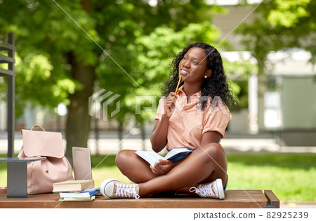 happy african student girl with book in city 82925239
