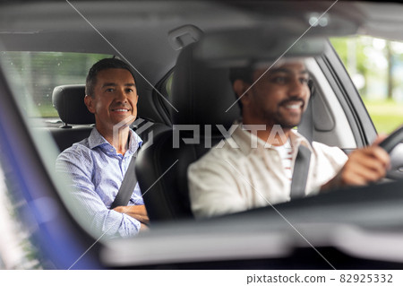 indian male driver driving car with passenger 82925332