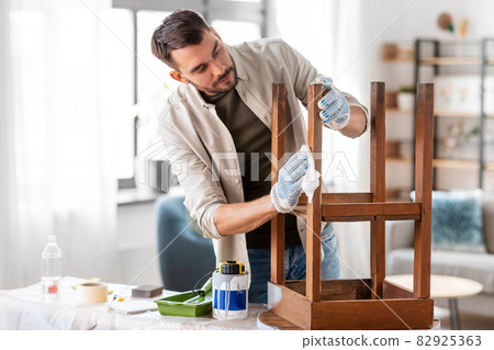 man cleaning old table surface with tissue man cleaning old table surface with tissue 82925363