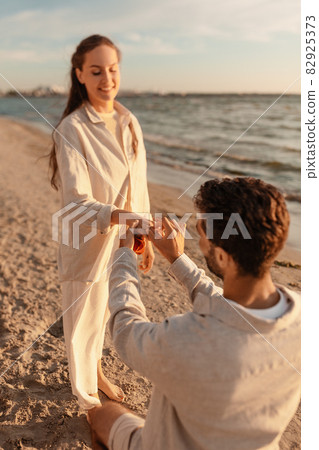 man with ring making proposal to woman on beach man with ring making proposal to woman on beach 82925373