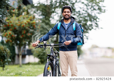 indian delivery man with bag and bicycle in city indian delivery man with bag and bicycle in city 82925424