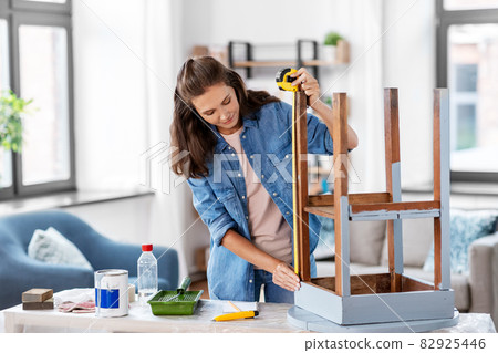 woman with ruler measuring table for renovation 82925446