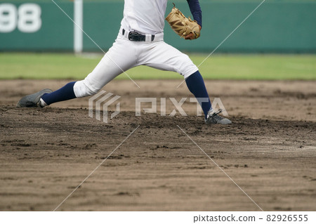 A pitcher throwing a white ball from the mound during a baseball game 82926555