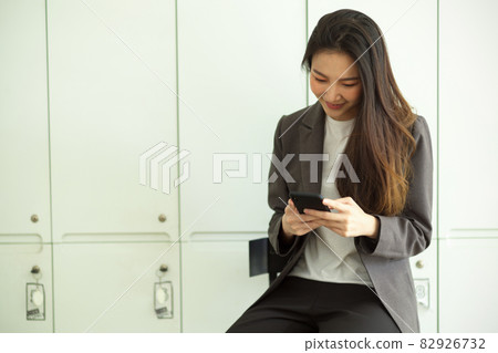 Attractive business woman reading an email or texting message on smart mobile phone Attractive business woman reading an email or texting message on smart mobile phone 82926732
