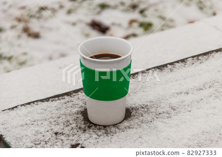 Cup of coffee on a snow covered table at winter 82927333