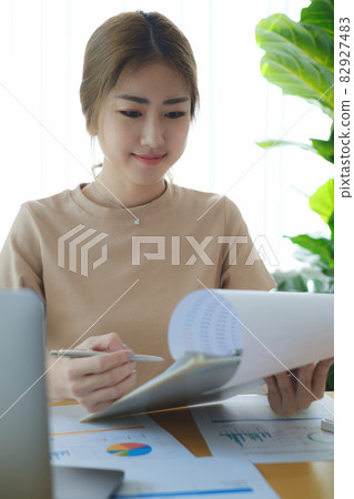 Business woman hand holding pen and data document, account or saving money or insurance concept. Business woman hand holding pen and data document, account or saving money or insurance concept. 82927483