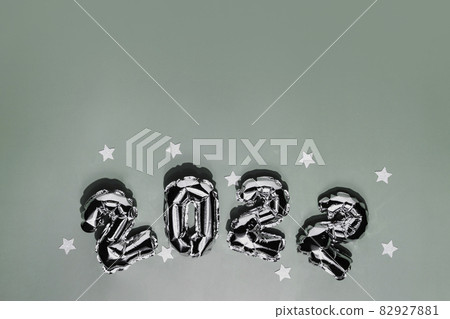 New Year 2022 or Christmas green background flat lay. Top view on 2022 balloon silver or metallic numbers with white star shapes. Invitation or greeting card concept. Festive mood. High quality photo New Year 2022 or Christmas green background flat lay. Top view on 2022 balloon silver or metallic numbers with white star shapes. Invitation or greeting card concept. Festive mood. High quality photo 82927881