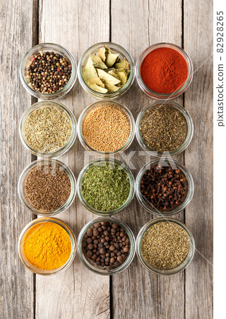 Various types of seasonings in bowls. Collection of seasonings on wooden background 82928265
