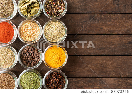 Collection of spices in bowls on wooden background with copyspace. Top view 82928266