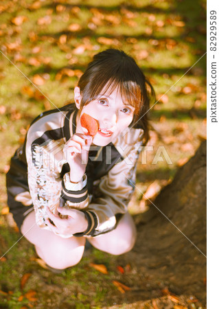 A cute girl who picks up red fallen leaves and makes her cute while taking a walk in the autumn park A cute girl who picks up red fallen leaves and makes her cute while taking a walk in the autumn park 82929589