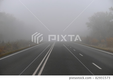 Bad weather driving - foggy hazy country road. Motorway - road traffic. Winter time. 82931573