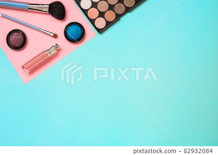 Various cosmetics and brushes on blue background 82932084