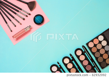 Make up essentials. Set of professional make up brushes, creams and shadows in jars on blue background. Make up essentials. Set of professional make up brushes, creams and shadows in jars on blue background. 82932092