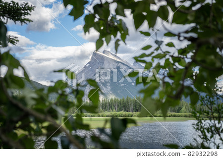 Majestic mountain Mount Rundle framed by tree branches ,Banff National Park, Canada Majestic mountain Mount Rundle framed by tree branches ,Banff National Park, Canada 82932298