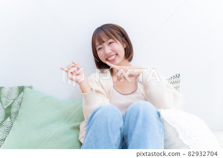 一個微笑的女人用雙手指著左邊 82932704