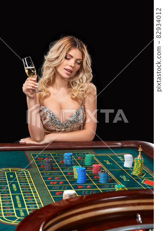 woman in a smart dress plays roulette. 82934012