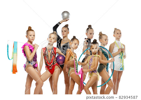 Studio shot of group of mixed-ages beautiful rhythmic gymnastics artists, girls posing isolated on white studio background. 82934587