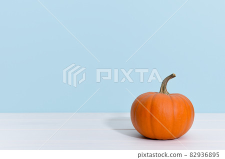 Ripe orange pumpkin on a blue background with copy space. 82936895