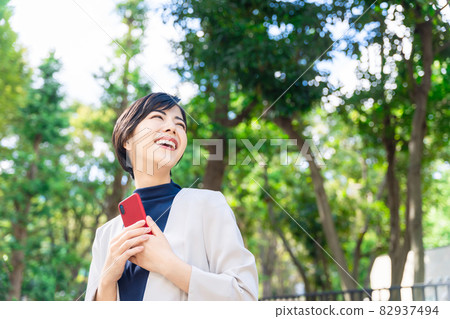 A woman who uses a smartphone in the city 82937494
