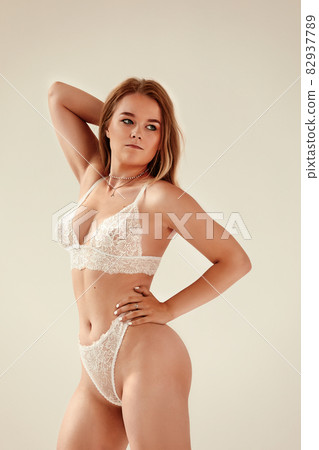 Attractive blonde beautiful woman posing in sexy clothes, looking at camera. Sensual portrait. Attractive blonde beautiful woman posing in sexy clothes, looking at camera. Sensual portrait. 82937789