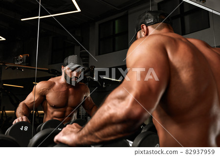 bald brutal sexy strong bodybuilder athletic fitness man pumping up abs muscles workout bodybuilding concept background bald brutal sexy strong bodybuilder athletic fitness man pumping up abs muscles workout bodybuilding concept background 82937959