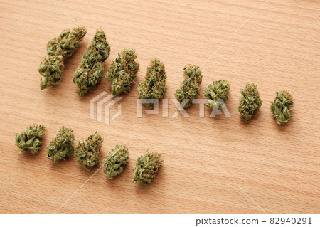 Marijuana outdoor buds in row on wooden background Marijuana outdoor buds in row on wooden background 82940291