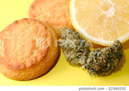 Cookies with CBD oil. Marijuana buds on yellow background Cookies with CBD oil. Marijuana buds on yellow background 82940292
