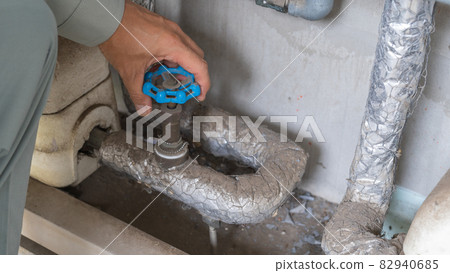 Turn the tap. Men in work clothes. Turn the tap. Men in work clothes. 82940685