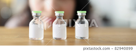 Woman looks at vaccine bottle and decides which one to choose 82940899