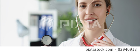 Portrait of smiling female doctor holding stethoscope closeup 82940918