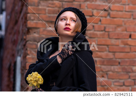 sad young woman in retro style on a brick wall background 82942511