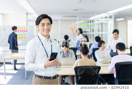 A businessman looking at a smartphone in the office A businessman looking at a smartphone in the office 82942918