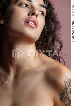 Close-up portrait of young beautiful woman looking away isolated over pink background. 82943460