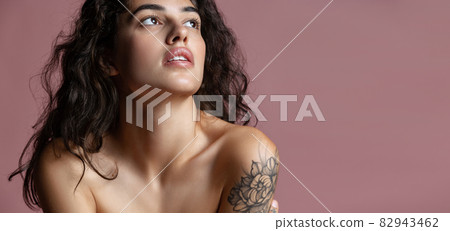 Cropped close-up portrait of young beautiful woman thoughtfully looking up isolated over pink background. Flyer Cropped close-up portrait of young beautiful woman thoughtfully looking up isolated over pink background. Flyer 82943462