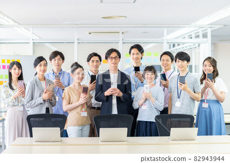 A large number of engineers with smartphones in the office A large number of engineers with smartphones in the office 82943944