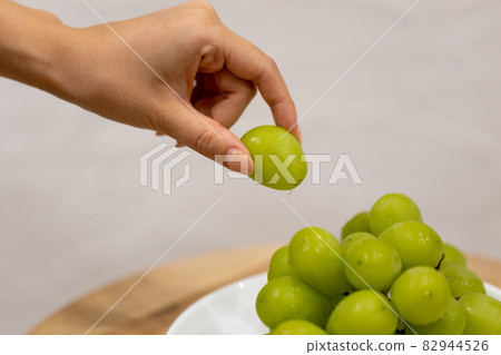 Hands of a young woman with a large Shine Muscat Hands of a young woman with a large Shine Muscat 82944526