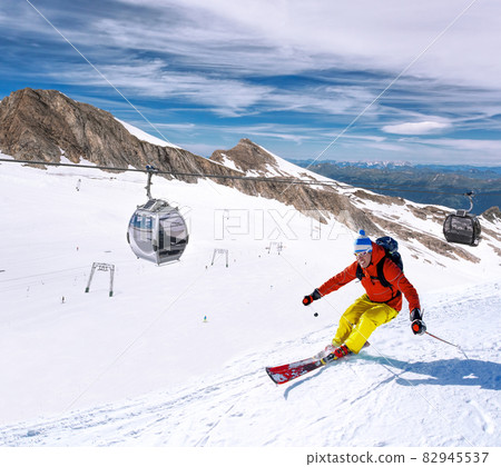 Skier skiing downhill during sunny day in high mountains, Kaprun glacier- Zell am see, Austria 82945537