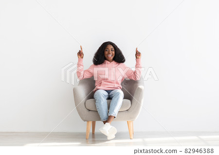 Positive african american lady pointing up at copy space Positive african american lady pointing up at copy space 82946388
