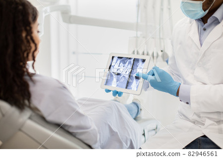 Black Dentist Doctor Showing Teeth Xray On Digital Tablet To Female Patient 82946561