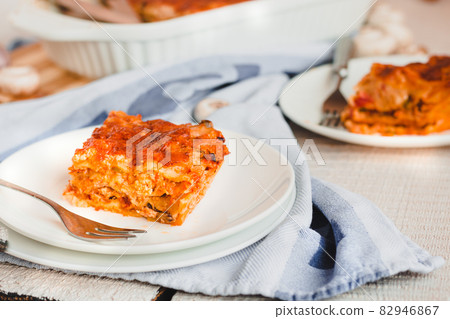 Piece of tasty hot lasagna served with on a white plate. Italian cuisine, menu, recipe. Homemade meat lasagna 82946867