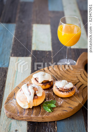Homemade buns with cinnamon and a glass of juice. High quality photo. 82947061