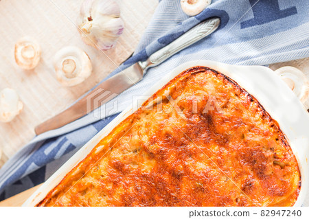 Young woman hands holding freshly fed meat lasagna on a white plate. Italian cuisine.Kinfolk and comfort food atmosphere concept. Young woman hands holding freshly fed meat lasagna on a white plate. Italian cuisine.Kinfolk and comfort food atmosphere concept. 82947240