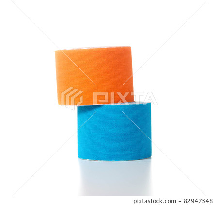 Blue and orange medical kinesiology tape on a white background. Isolate, teping, close-up 82947348