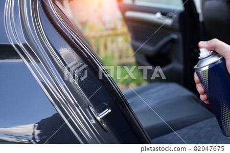 Silicone grease lubrication of rubber door seals in a passenger car, close-up 82947675
