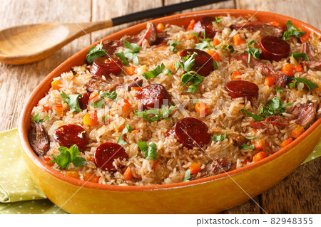Portuguese duck rice arroz de pato cooked with red wine, onion, carrot and chorizo close up in the baking dish. Horizontal 82948355