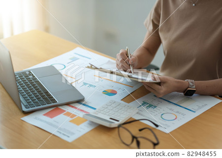 Cropped shot of accountants work analyzing financial reports on a laptop at his office, business analytics concept 82948455