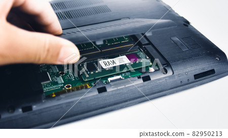 A technician inspects the RAM of a laptop computer by opening the lid (Random Access Memory) A technician inspects the RAM of a laptop computer by opening the lid (Random Access Memory) 82950213