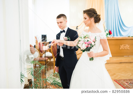 Bride and groom holding candles in church 82950886