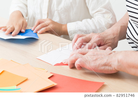 Children and grandmother playing with origami Children and grandmother playing with origami 82951746